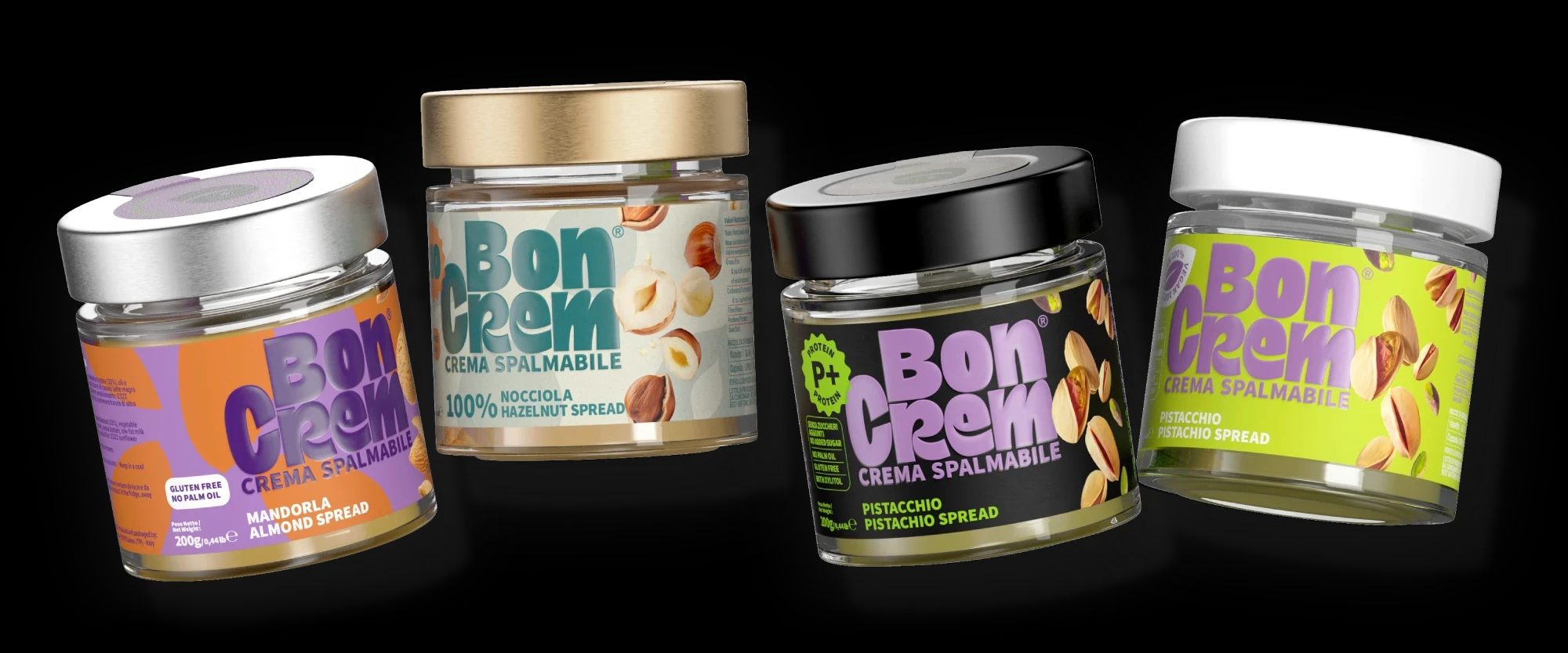 Four BonCrem jars in a row on black: almond, 100% hazelnut, pistachio Protein+ and pistachio spread.